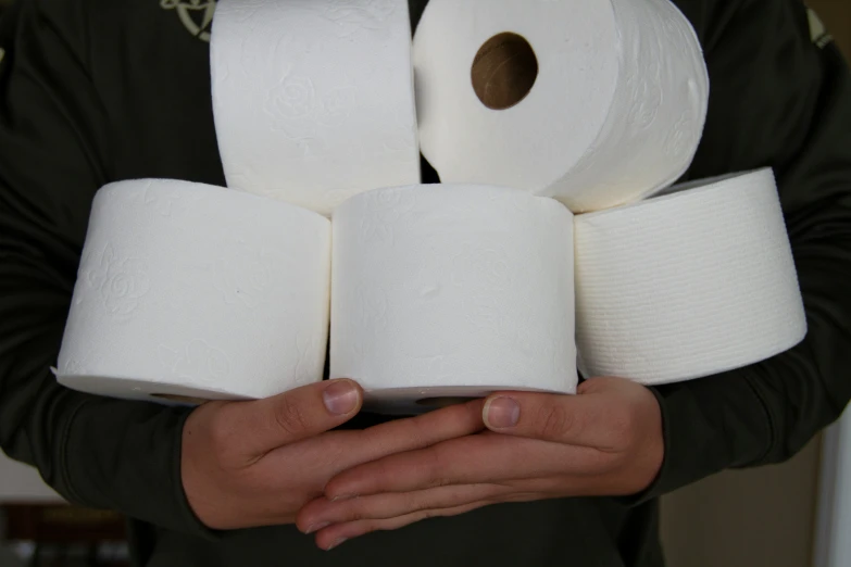 a man holding a handful of white toilet paper