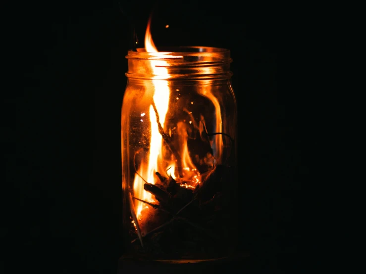 a jar with burning matches inside of it