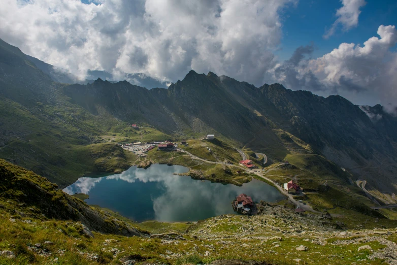 mountains and a large lake with a few houses on the far side