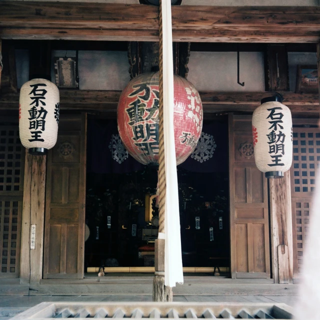 two red lanterns hanging from the ceiling of a building