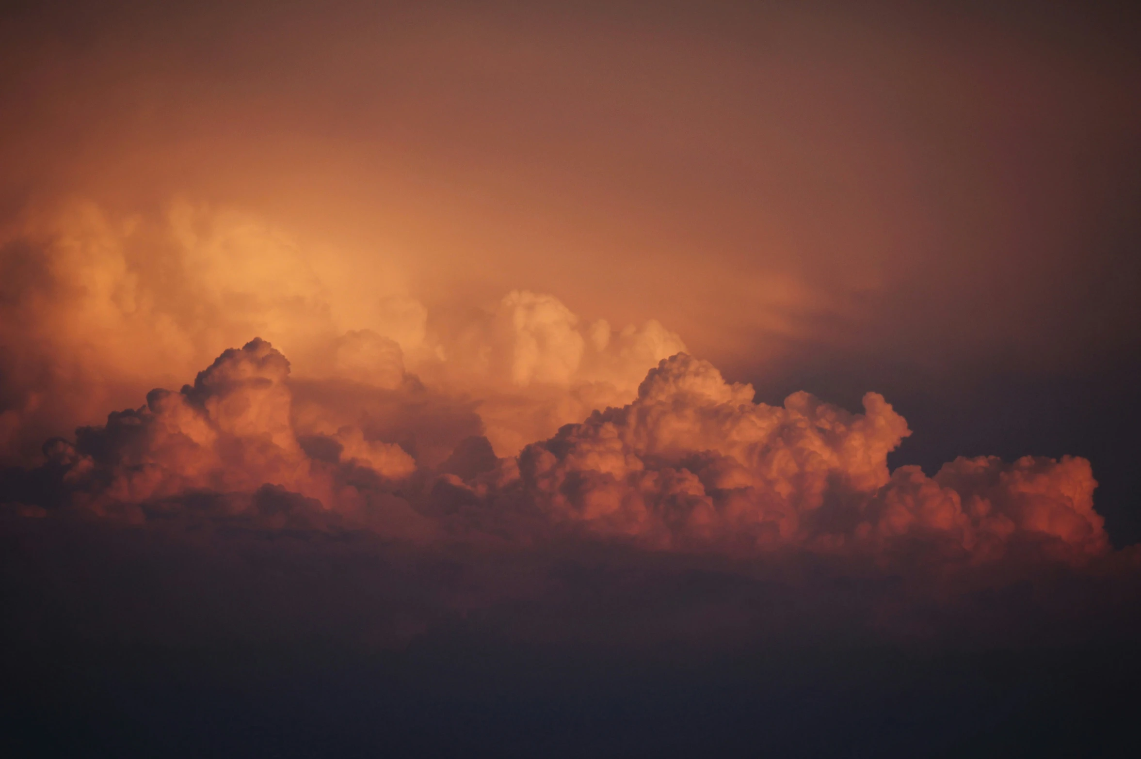 a large cloudy sky filled with clouds at sunset