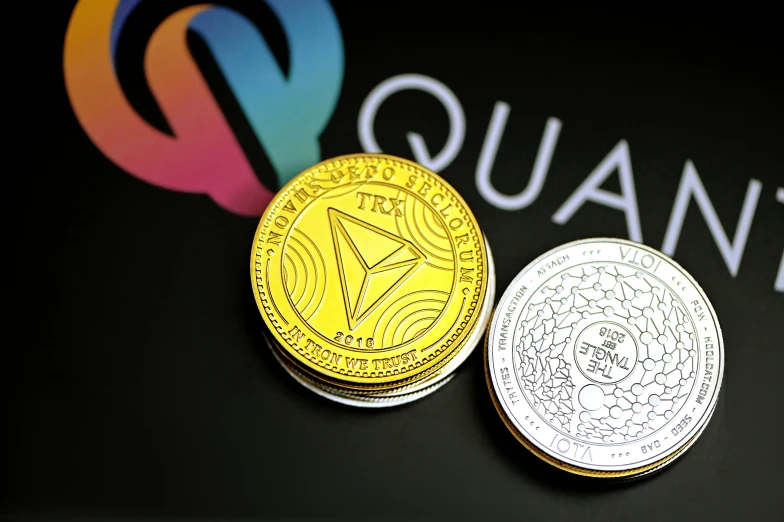 two coins are in front of the quasa logo