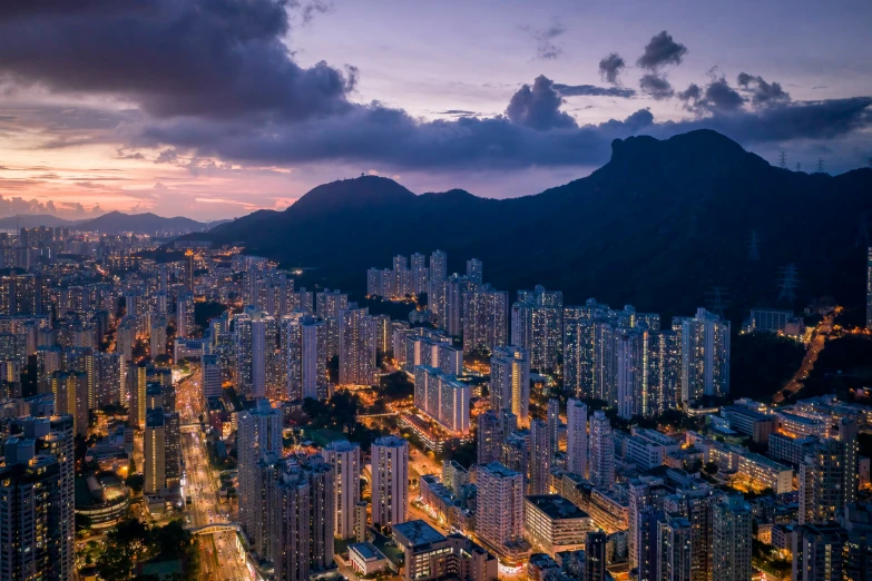 a city skyline with skyscrs in the middle and mountains behind them