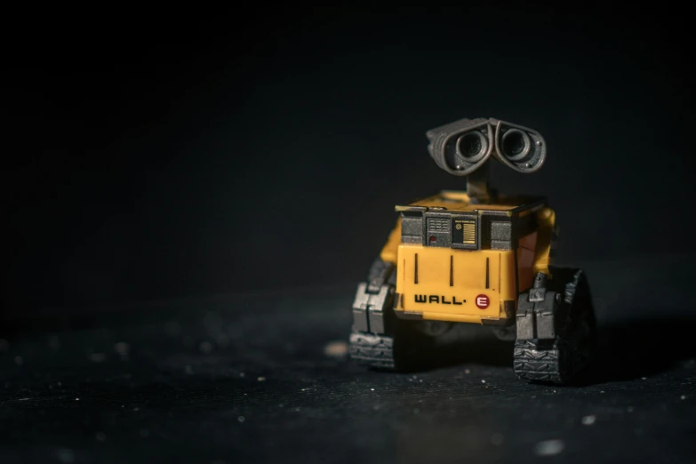 a small yellow robot sits on the ground