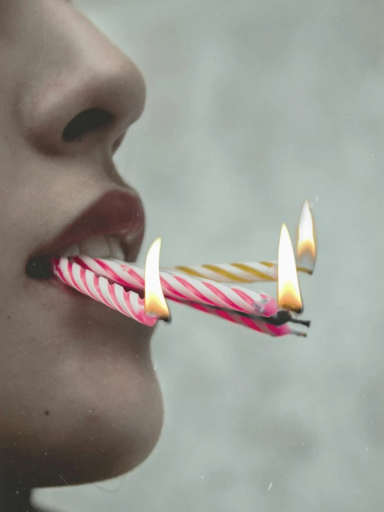 woman biting into four candles with her tongue