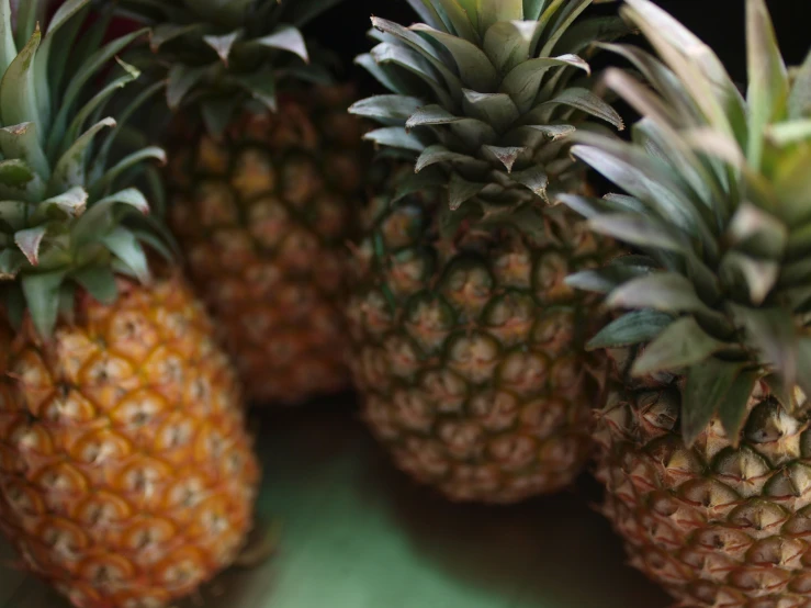 four pineapples stacked together on a table