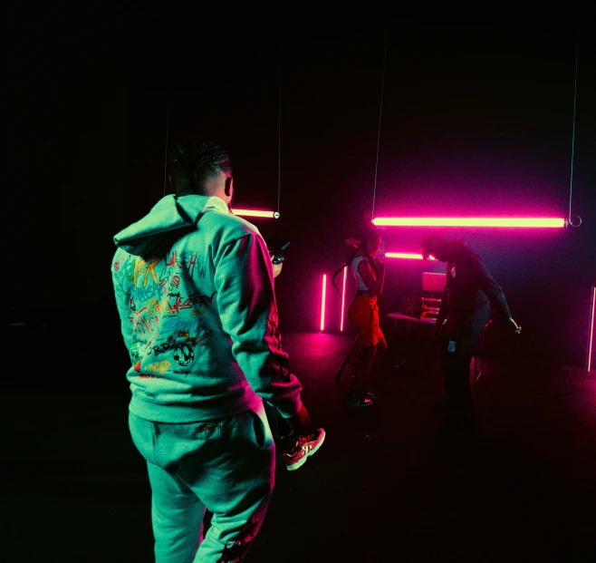 a man standing in the dark near neon lights