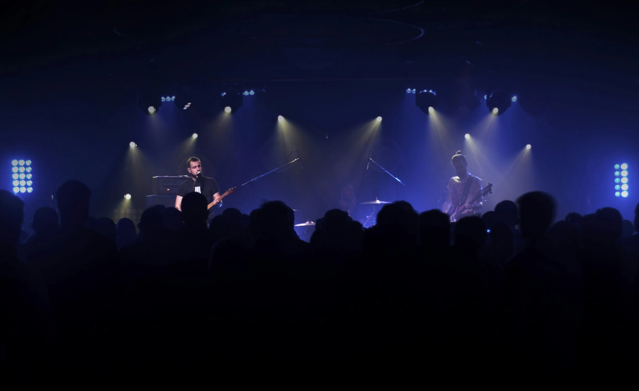 a band playing on stage with lighting around them