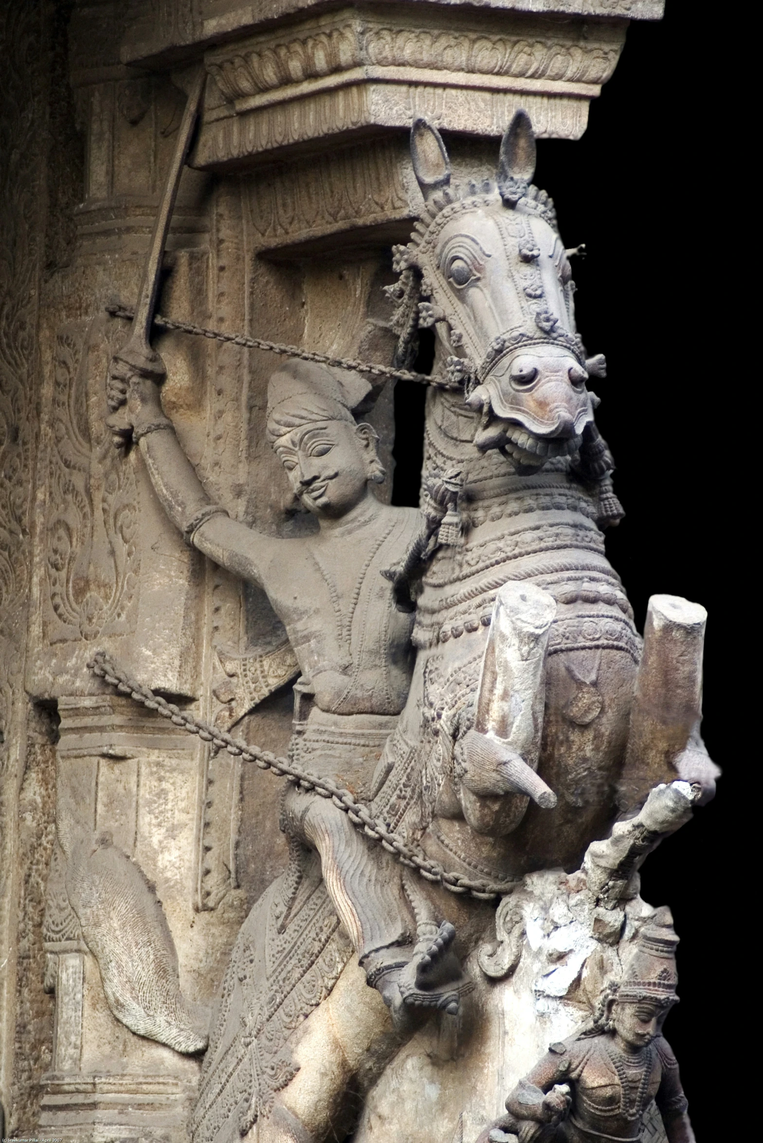 a statue of a man riding a horse that is standing next to a tall building