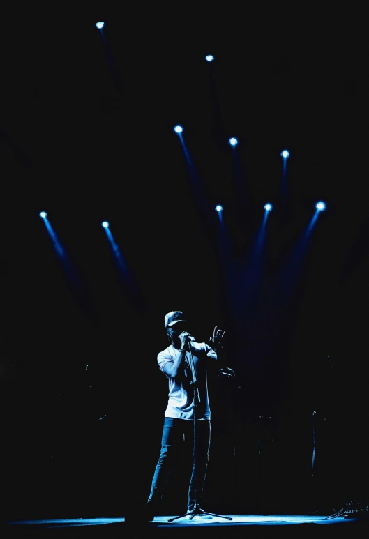 someone in a white shirt is singing into microphone