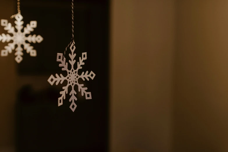 two christmas ornaments are hanging from chains