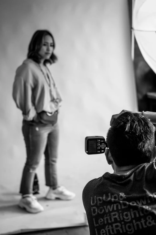 a black and white po of a person taking a pograph with a cell phone