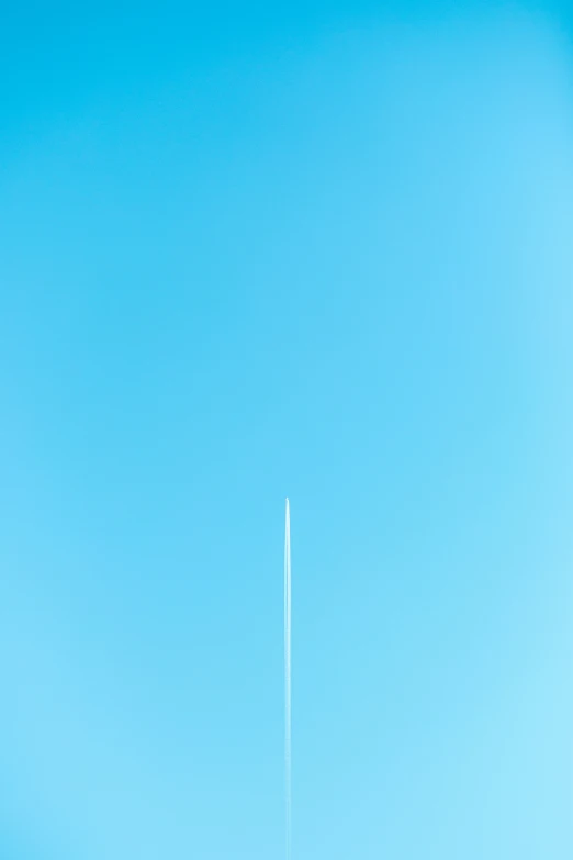 a man flying through the air under a blue sky