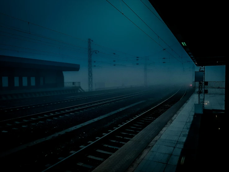 a dark train station with some train tracks