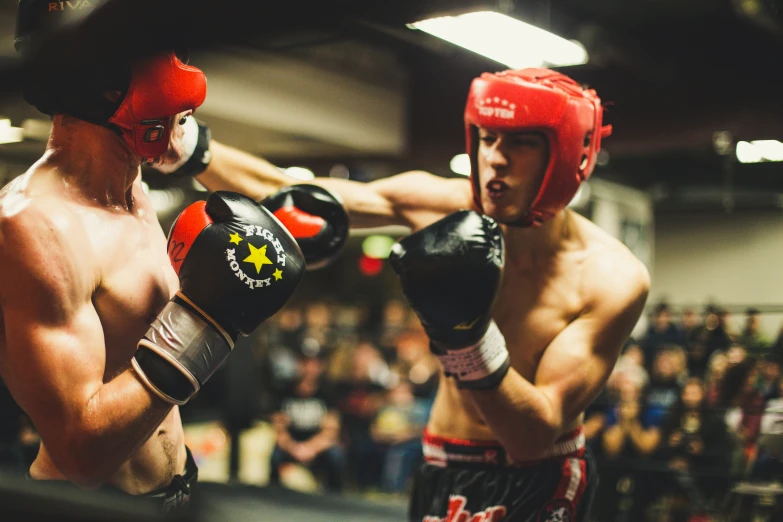 two boxers in red and black boxing trunks during a bout