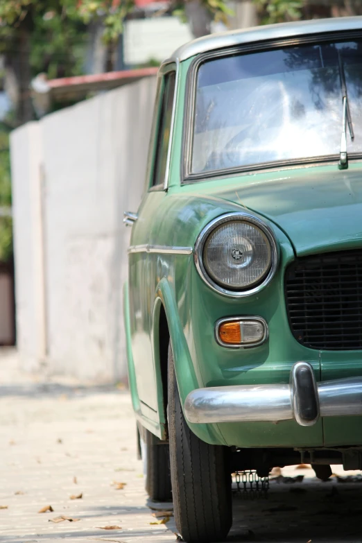 a green old station wagon parked on the street