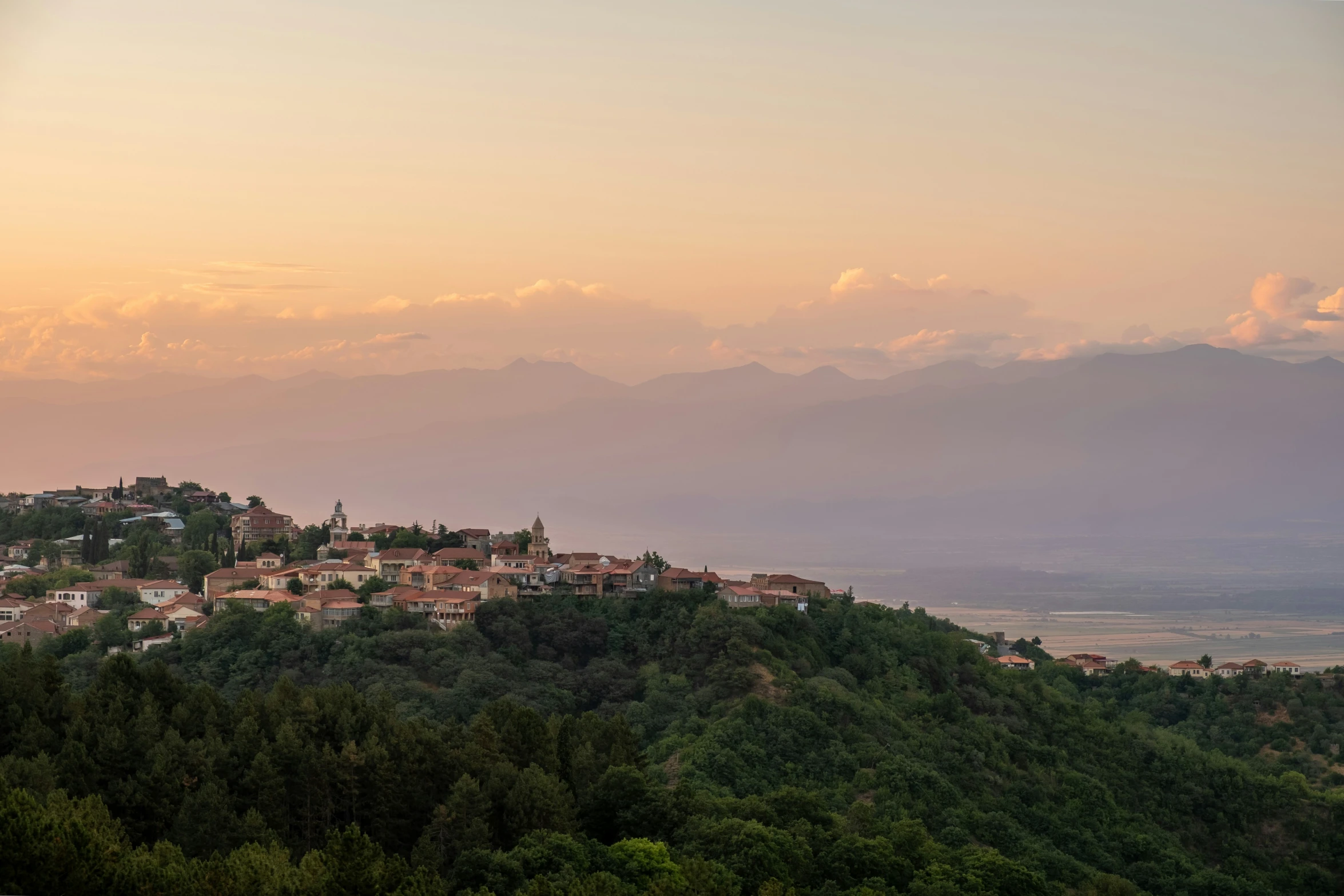 the town sits on a hilltop of trees and is set among many mountains