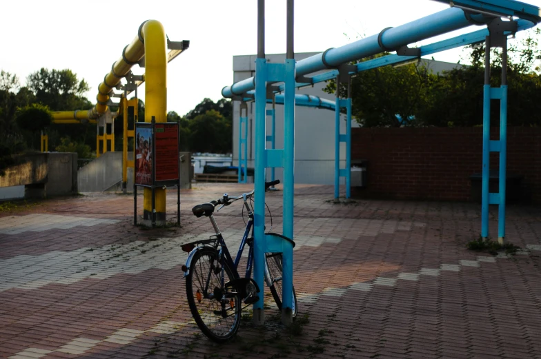 a bicycle parked on the sidewalk near a blue metal structure