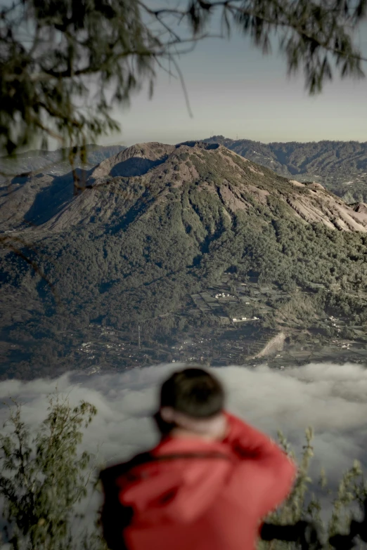 person looking at the mountains from a hill top