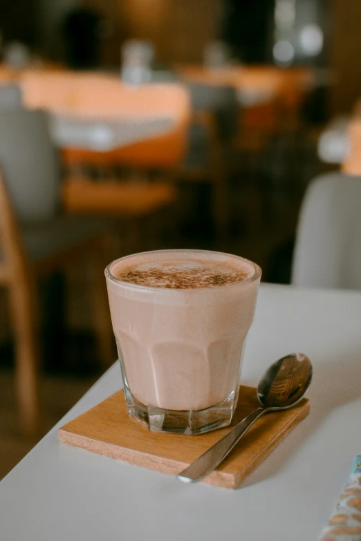 a glass with a chocolate substance in it on a wooden place mat