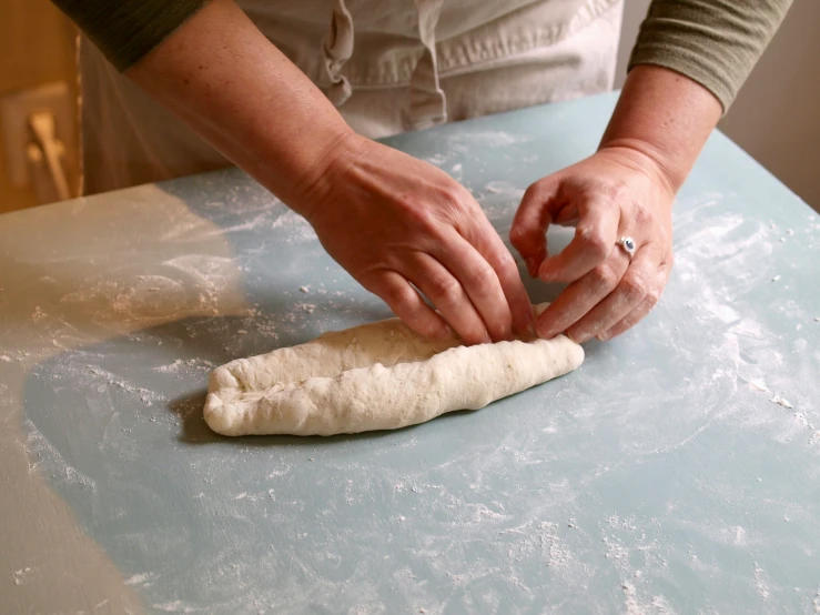 the woman in an apron is making bread