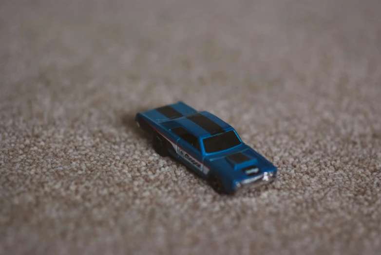 a toy car laying on the floor on a carpet