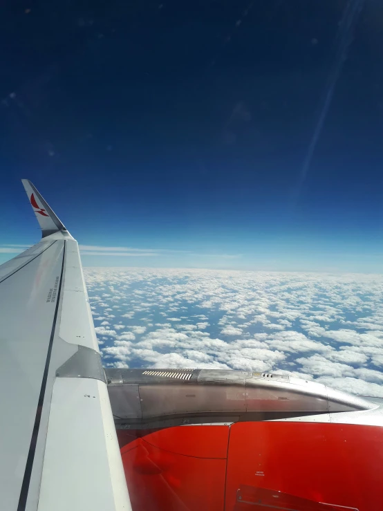 the view from inside of an airplane window is out over clouds