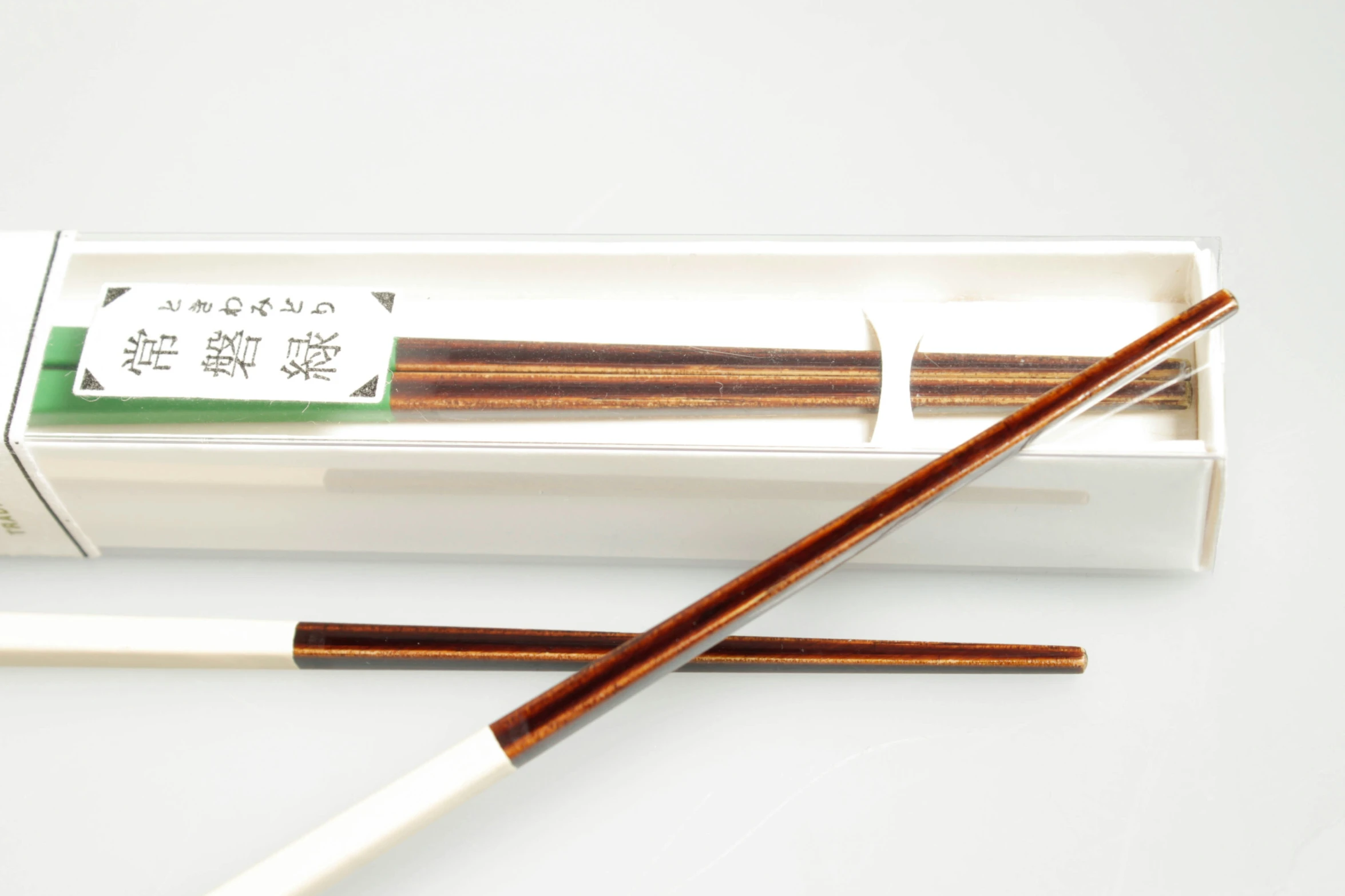 chopsticks in a box sitting next to a container