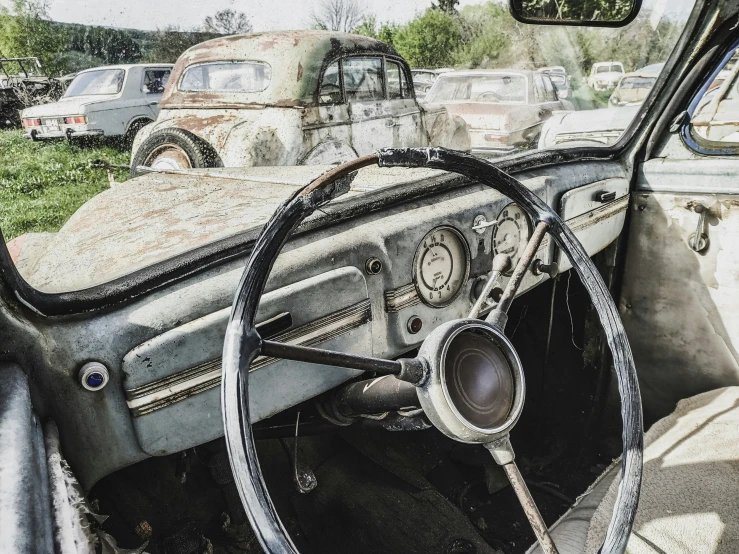 an old and rusty car in the grass