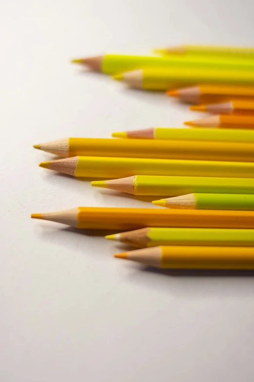 colored pencils lined up in a row on a white surface