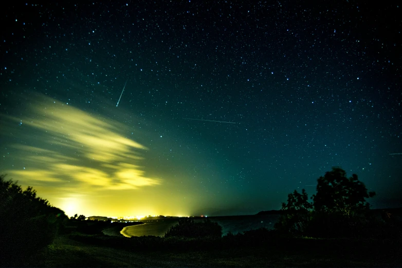 some green and black stars lights clouds and trees