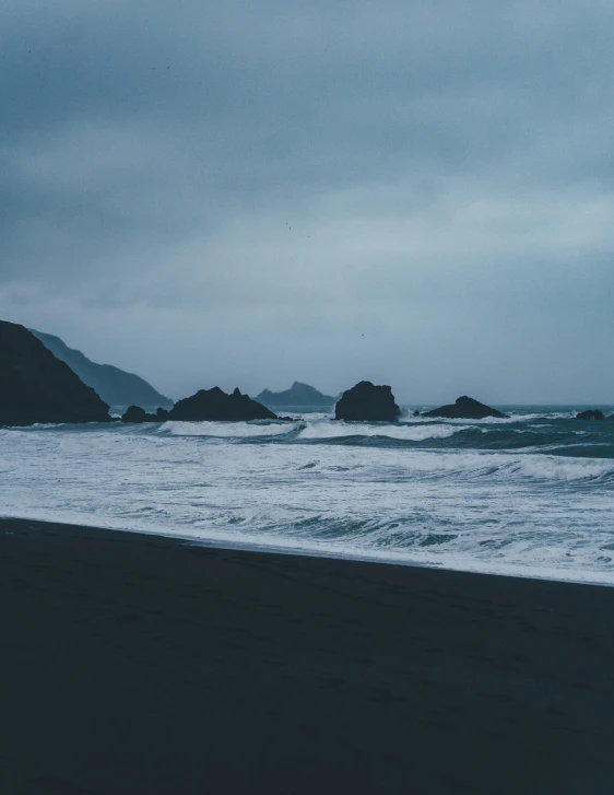 a beach covered in lots of small rocks near the water