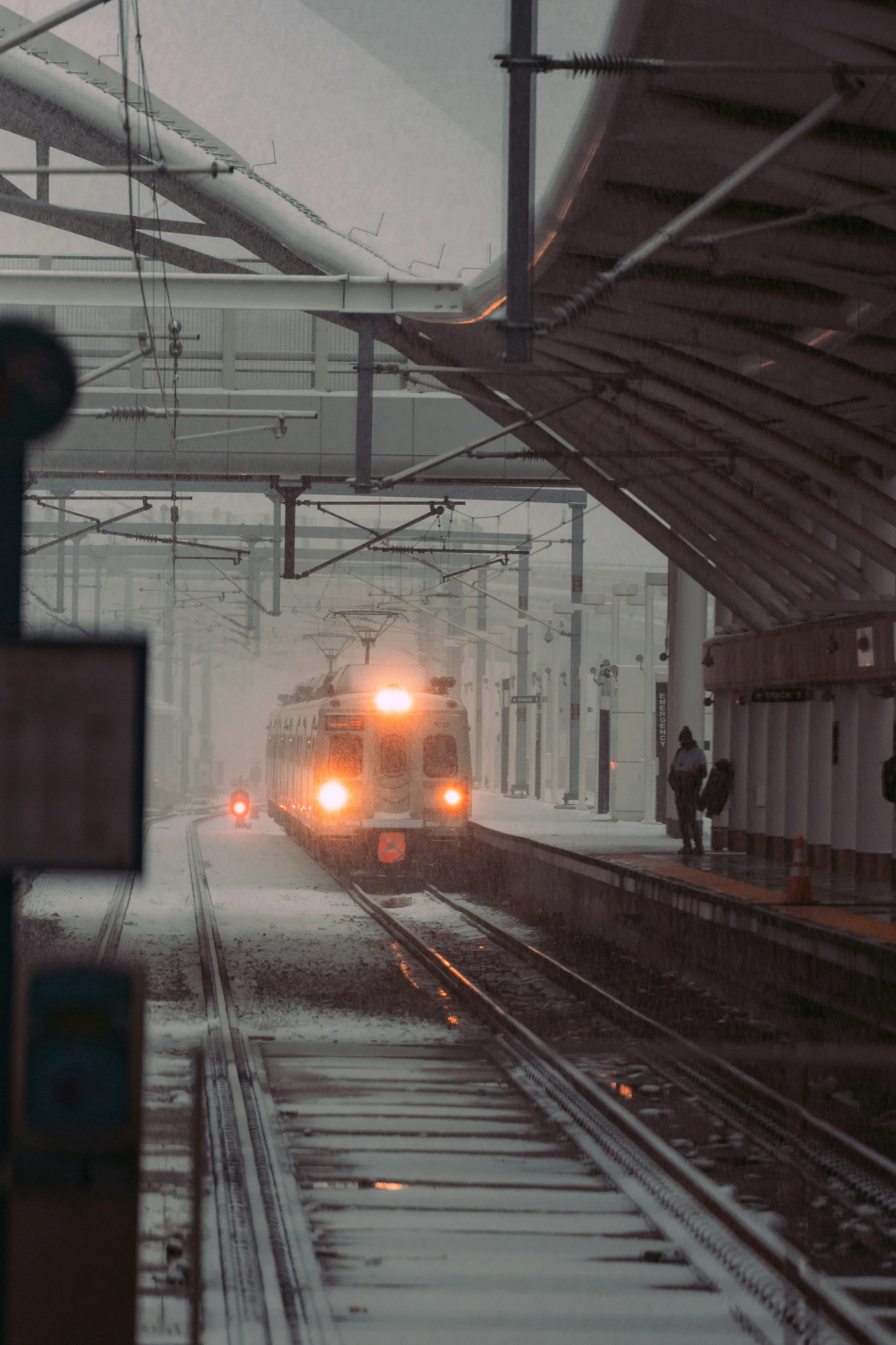 a commuter train pulling into the train station in the snow