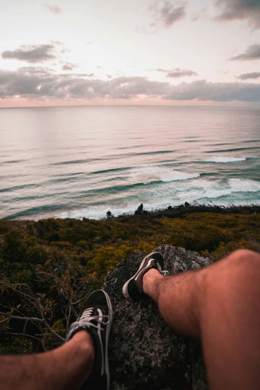 man resting in the grass with view of ocean and beach