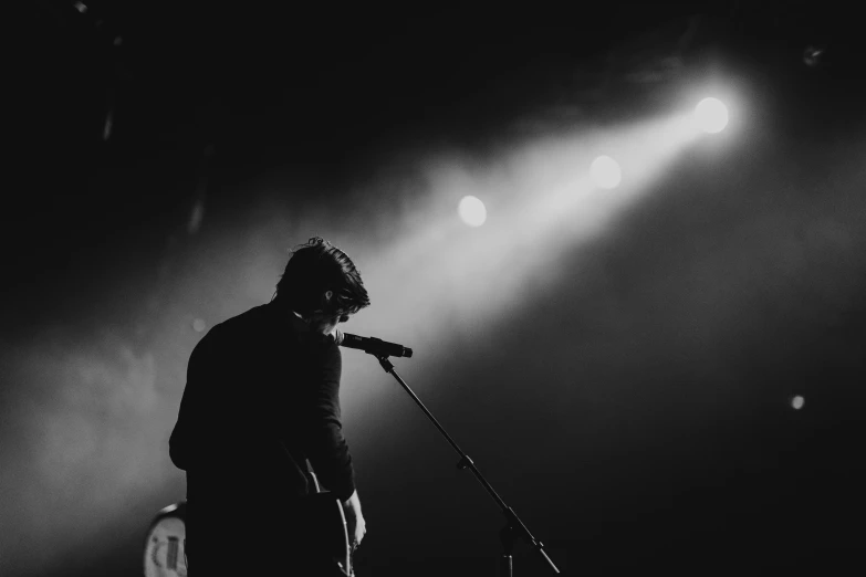 a man standing next to a microphone on stage