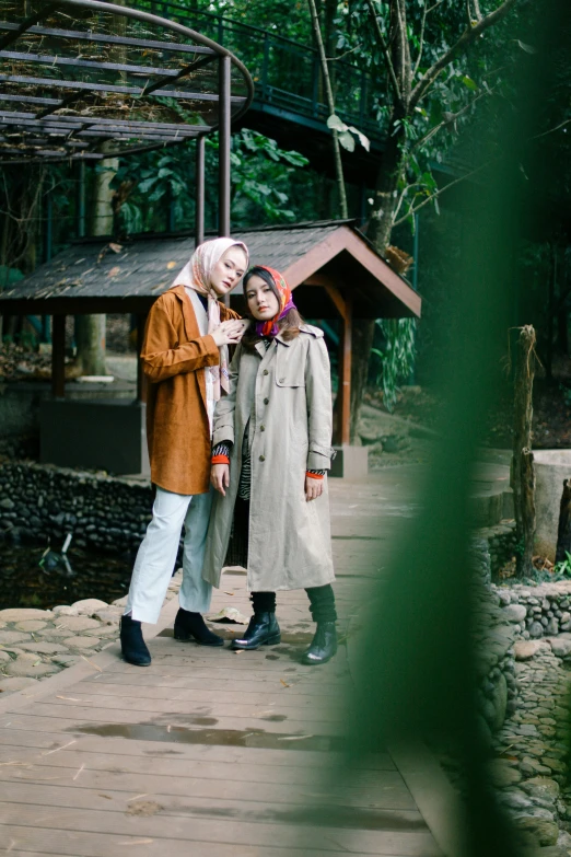 a couple taking a picture outside by a pond