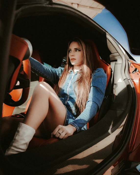 a woman in shorts and boots sitting inside of a car