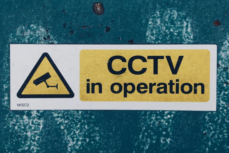 a yellow sign that says cctv in operation