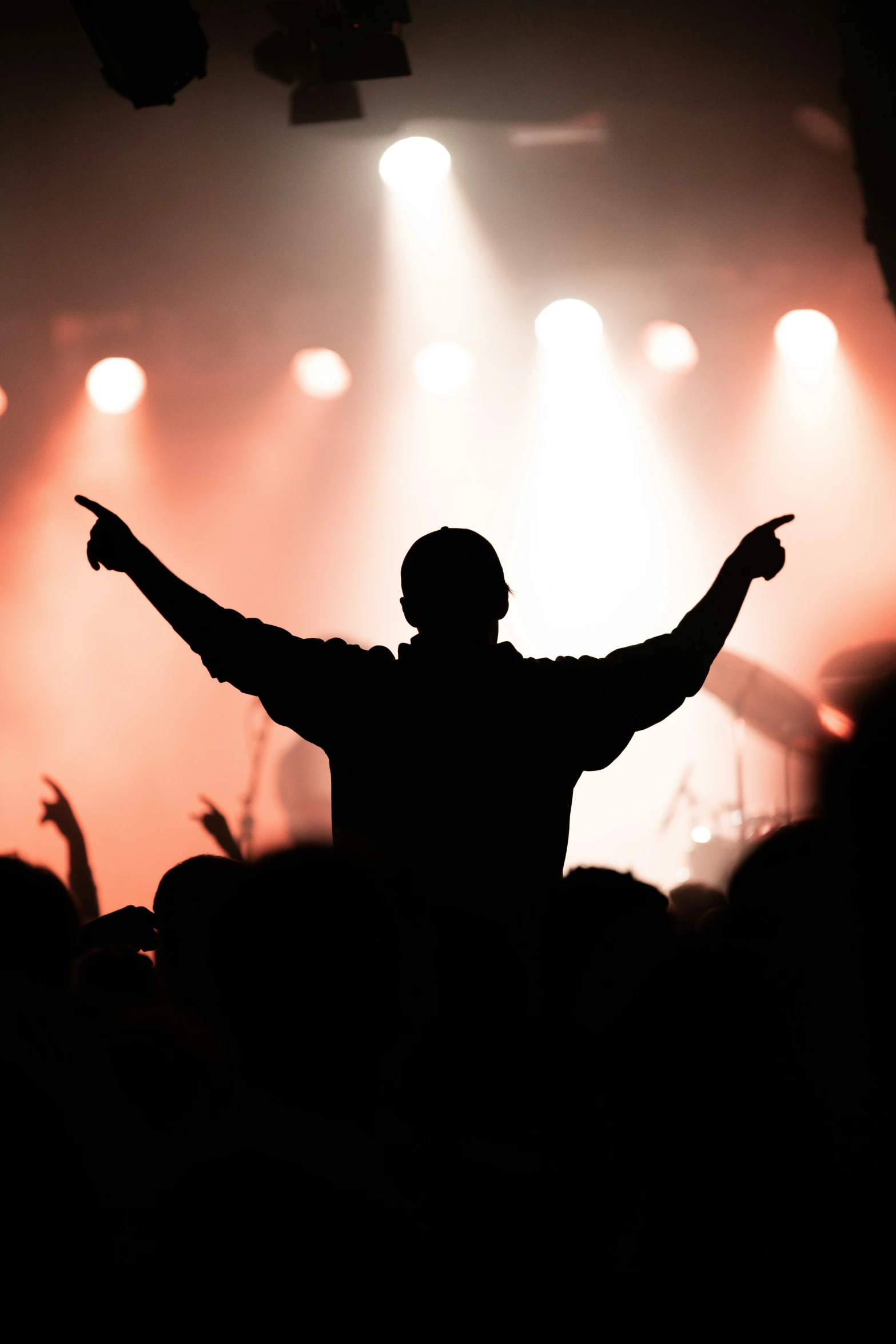 a person with their arms outstretched in front of a crowd