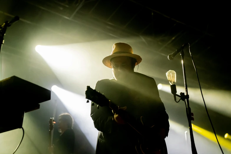 a musician playing his guitar in the spotlight