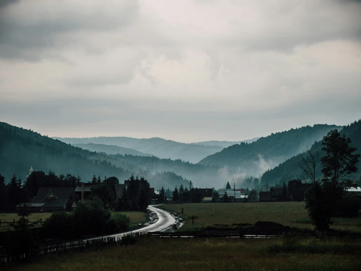 the mountains are covered in misty mist and the road to the bottom has long white lights