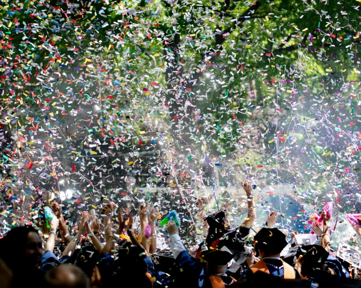 many people watching and holding up confetti