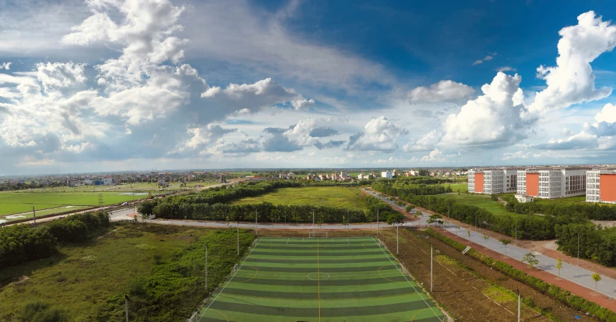 a scenic, wide field with many buildings on both sides