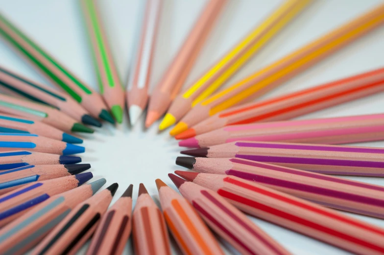 a circular arrangement of colorful pencils on a white surface