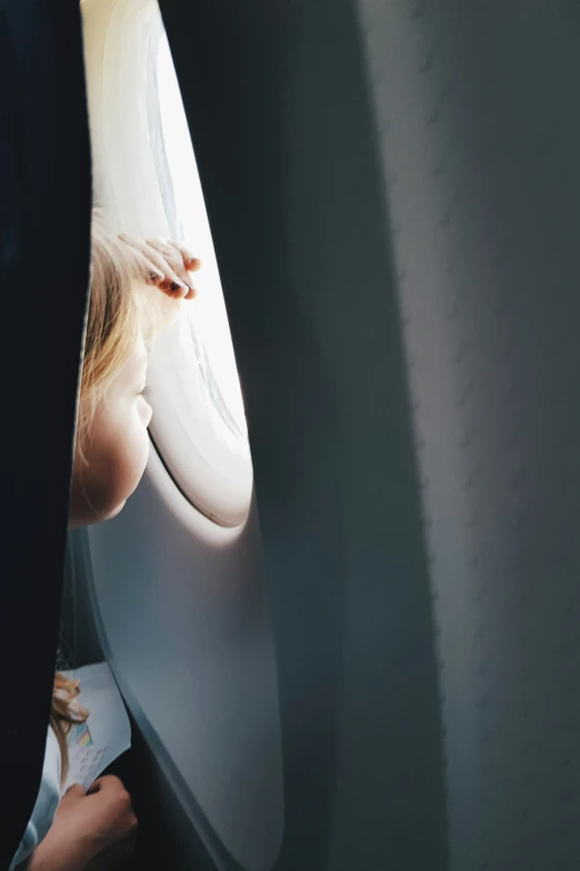 a child looks out of an airplane window