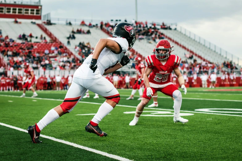 two football players run on the field in a game