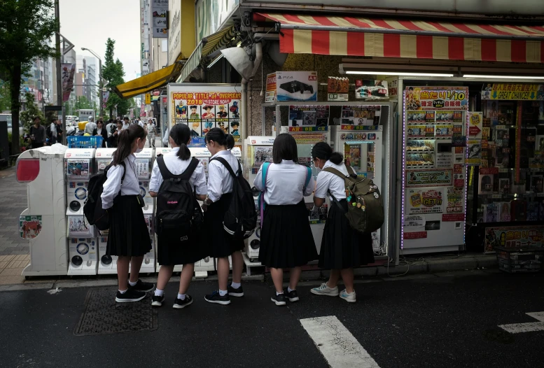 four girls are lined up in front of a candy shop