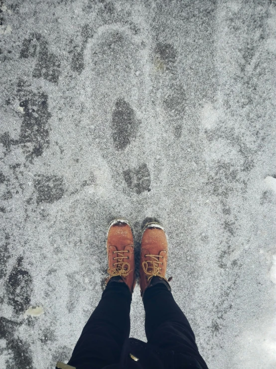 a person wearing boots standing in snow