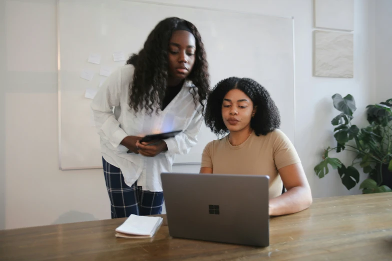 two women look at soing on their laptop screen