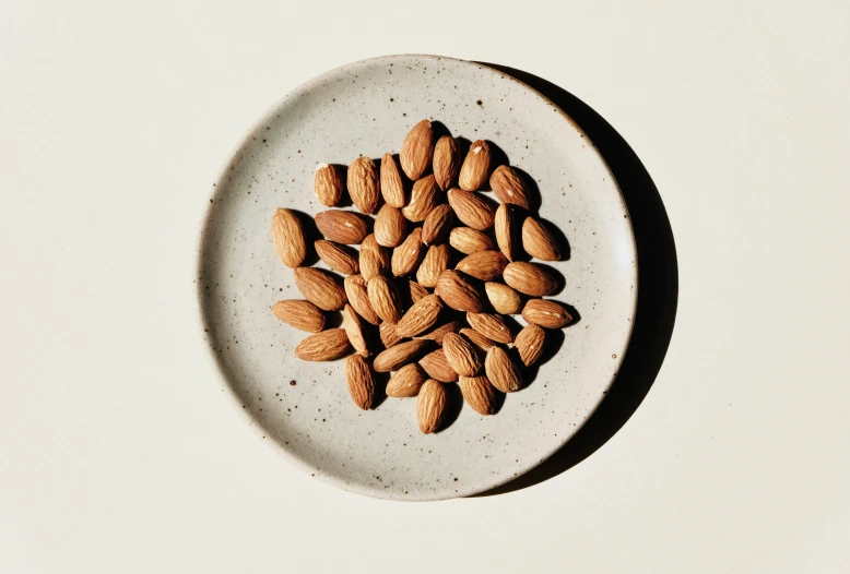 almonds are scattered on a white plate